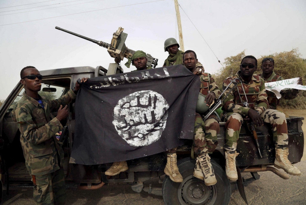 Nigérijskí vojaci držia vlajku džihádistickej organizácie Boko Haram, ktorú ukoristili po dobytí mesta Damasak. FOTO: REUTERS