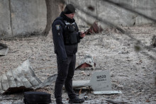 Príslušník polície stojí vedľa úlomkov zneškodneného dronu. Na jednom z nich možno rozoznať nápis „Za Riazaň“. FOTO: REUTERS