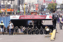 Policajti kráčajú vedľa demonštrantov, ktorí sa zúčastňujú pochodu požadujúceho rozpustenie Kongresu a usporiadanie demokratických volieb namiesto toho, aby uznali Dinu Boluarteovú za peruánsku prezidentku. FOTO: Reuters
