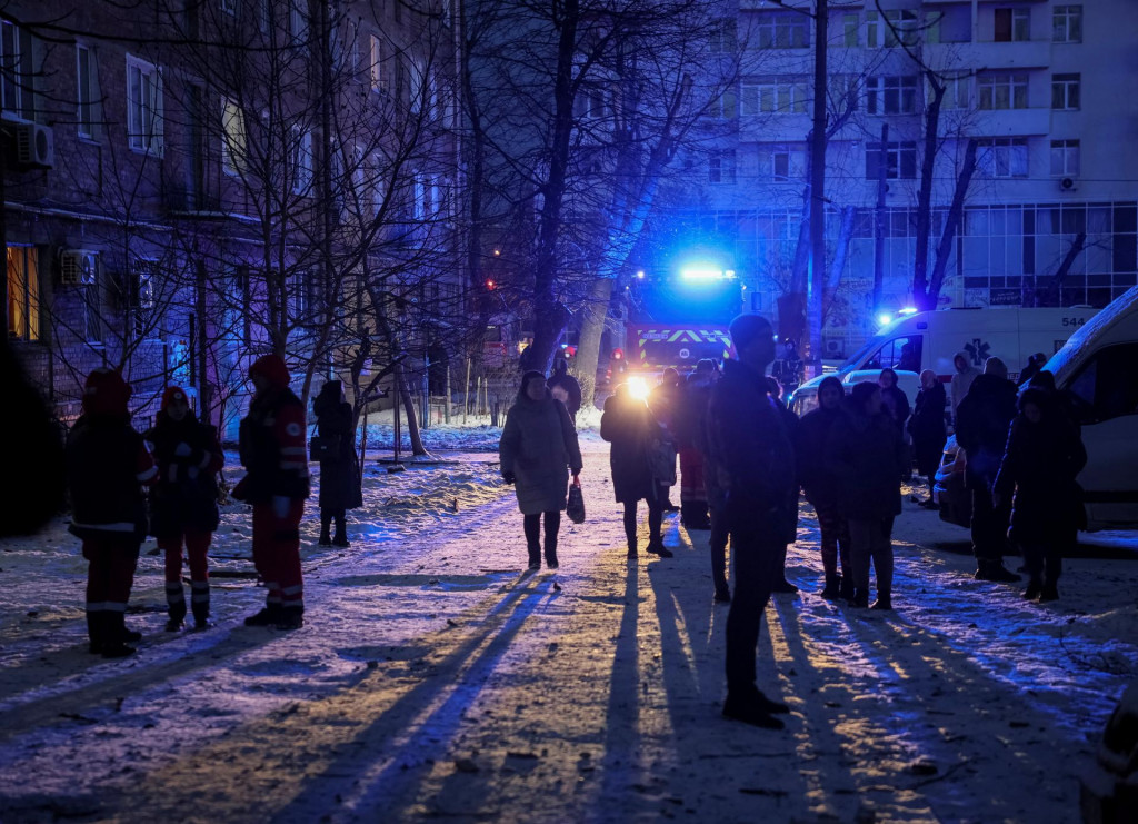 Kyjevčania sa zhromažďujú neďaleko budovy zničenej útokom ruského bezpilotného lietadla, 14. decembra 2022. FOTO: REUTERS