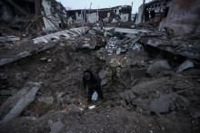 

Polícia a vyšetrovatelia kontrolujú kráter na mieste priemyselnej oblasti zničenej ruským raketovým útokom. FOTO: Reuters