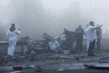 

Policajní forenzní experti skúmajú miesto po výbuchu bomby vo vozidle, ktoré stálo na kraji cesty. FOTO: Reuters