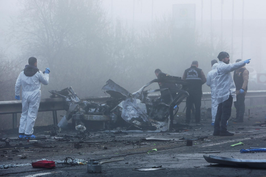 

Policajní forenzní experti skúmajú miesto po výbuchu bomby vo vozidle, ktoré stálo na kraji cesty. FOTO: Reuters