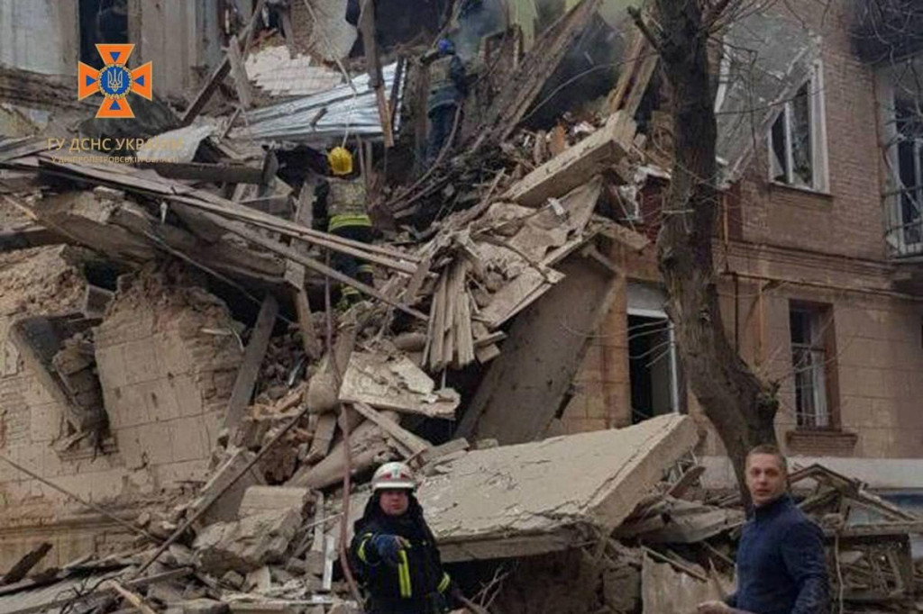 Záchranári pracujú v obytnej budove poškodenej ruskou raketou počas útoku na Ukrajinu. FOTO: Reuters