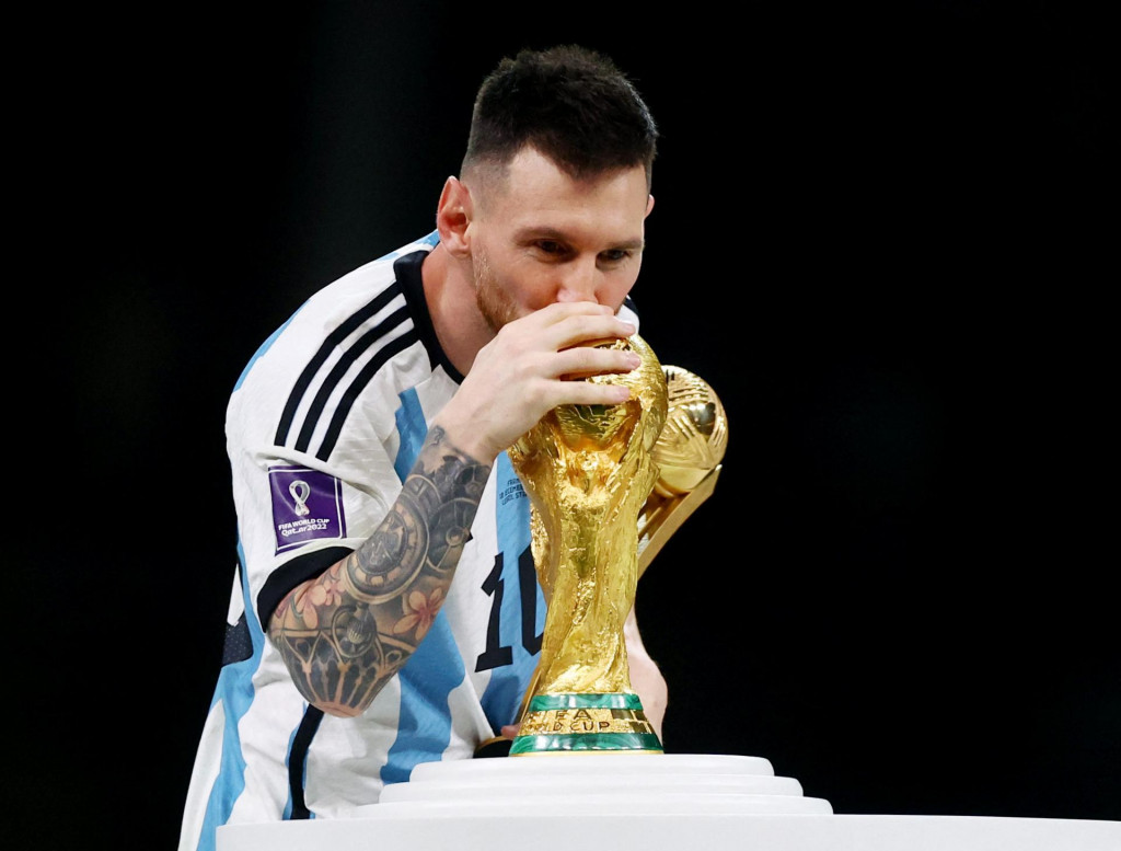 Lionel Messi symbolicky bozkáva trofej po víťazstve nad Francúzskom po finálne MS v Katare. FOTO: REUTERS