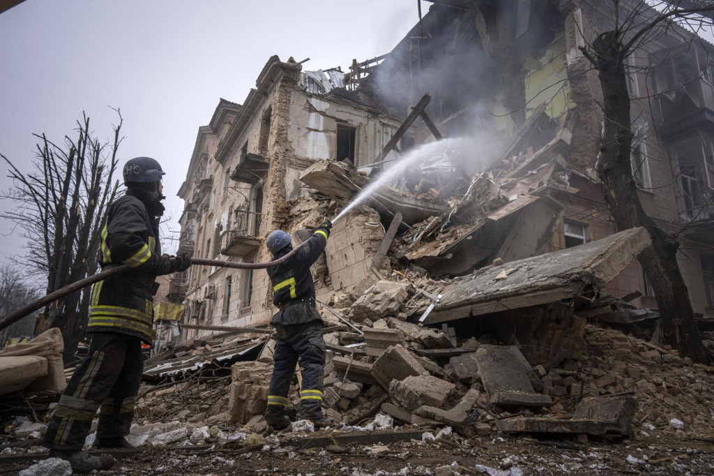 Hasiči hasia požiar v budove poškodenej pri ruskom raketovom útoku. FOTO: TASR/AP