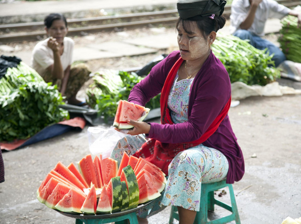 Predavačka krája melón pre zákazníkov na železničnej stanici v Rangúne. FOTO: TASR/AP