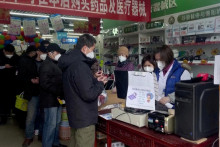 Ľudia stoja v rade na nákup liekov v lekárni v Pekingu. FOTO: Reuters