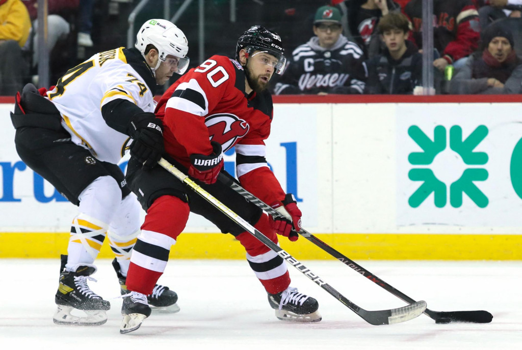 Tom&aacute;&scaron; Tatar pos&uacute;va puk po ľade, zatiaľ čo Jake DeBrusk br&aacute;ni počas druhej tretiny v Prudential Center. FOTO: REUTERS