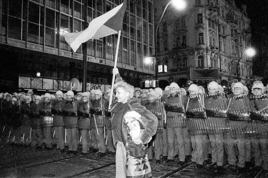 Demonštrantka s československou vlajkou pred policajným kordónom na Národnej triede v Prahe v novembri 1989. FOTO: Profimedia