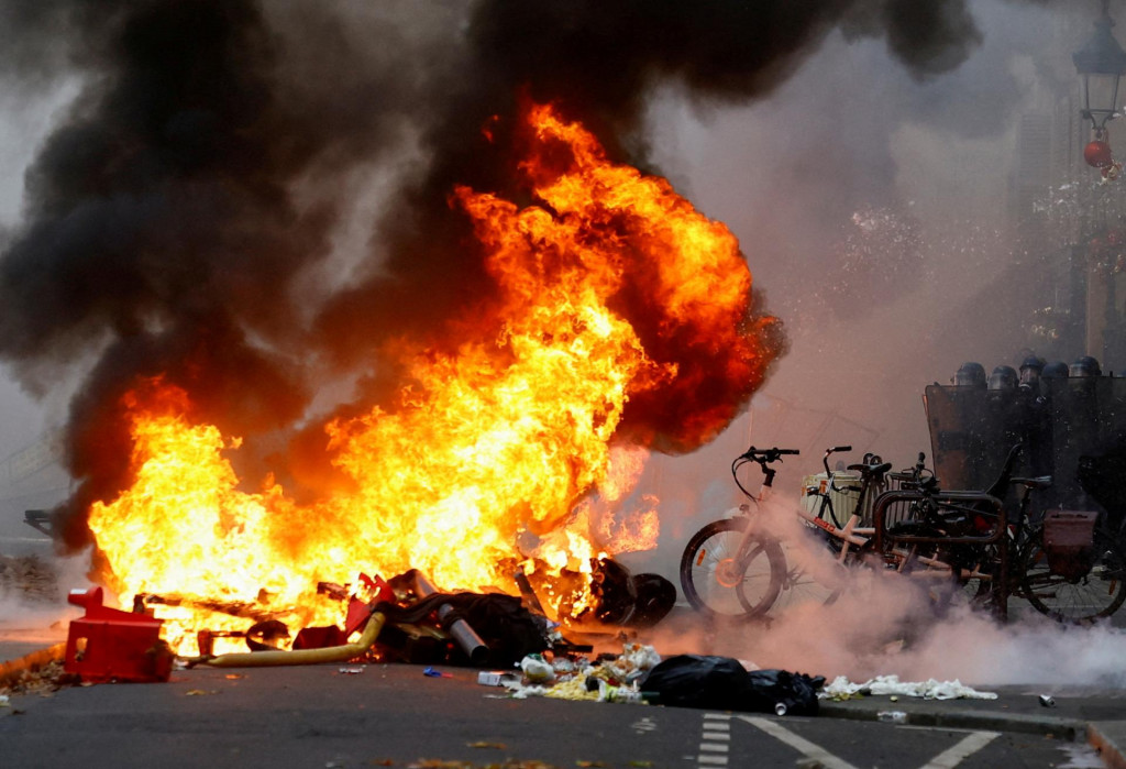 Z ohňa sa valí dym, keď sa členovia kurdskej komunity zúčastňujú demonštrácie po streľbe v Paríži. FOTO: Reuters