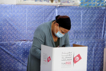 Žena stojí za plentou vo volebnej miestnosti v Tunise v Tunisku. FOTO: TASR/AP