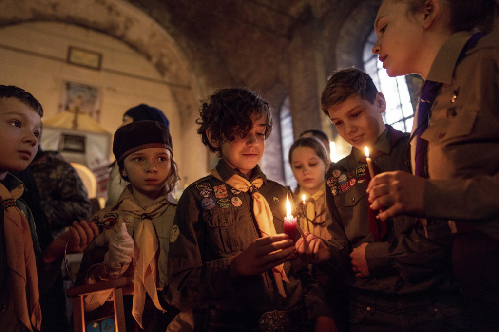 Ukrajinskí skauti držia betlehemské svetlo mieru počas vianočnej omše v ukrajinskom Charkove. FOTO: TASR/AP
