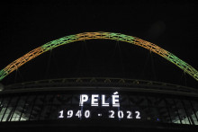 Oblúk štadióna Wembley v Londýne je vysvietený v brazílskych národných farbách na pamiatku zosnulej futbalovej legendy Pelého. FOTO TASR/AP