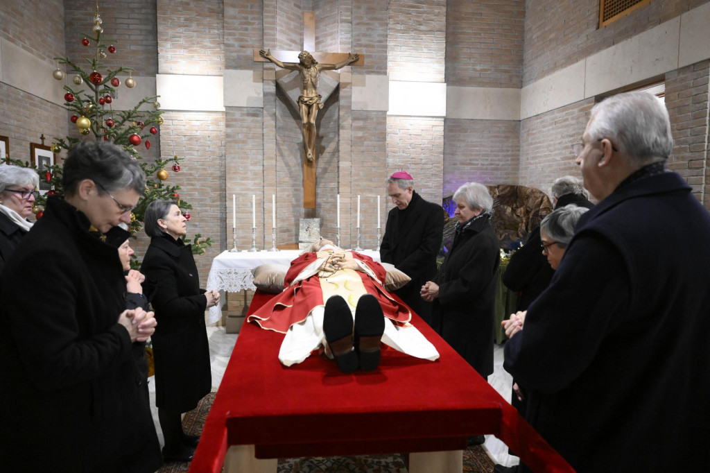 Arcibiskup George Gänswein (uprostred) sa modlí pred telom zosnulého emeritného pápeža Benedikta XVI. v kaplnke Kláštora Matky Cirkvi. FOTO: TASR/AP