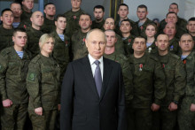 Ruský prezident Vladimir Putin svoj zatiaľ najdlhší novoročný prejav predniesol na pozadí skupiny vojakov v uniformách s medailami na prsiach. FOTO: Reuters