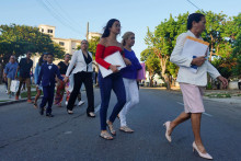 Ľudia kráčajú smerom k americkej ambasáde v Havane na Kube. FOTO: Reuters