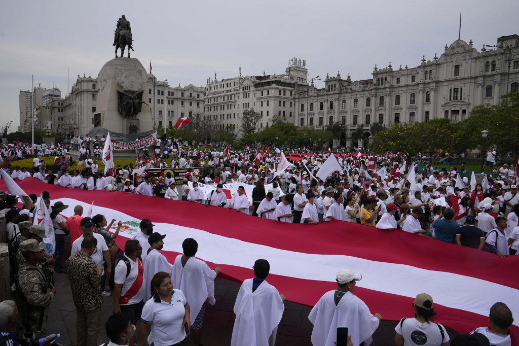 Demonštranti držia obrovskú vlajku počas pochodu za mier na námestí San Martin v Lime v Peru. FOTO: TASR/AP