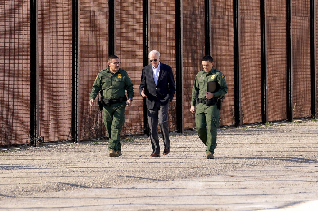 Prezident Joe Biden sa rozpráva s príslušníkmi pohraničnej hliadky, keď kráča popri hraničnom plote. FOTO: Reuters
