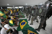 Podporovatelia bývalého brazílskeho prezidenta Jaira Bolsonara sedia pred políciou v prezidentskom paláci. Polícia v brazílskom hlavnom meste Brasília zatkla stovky osôb. FOTO: TASR/AP