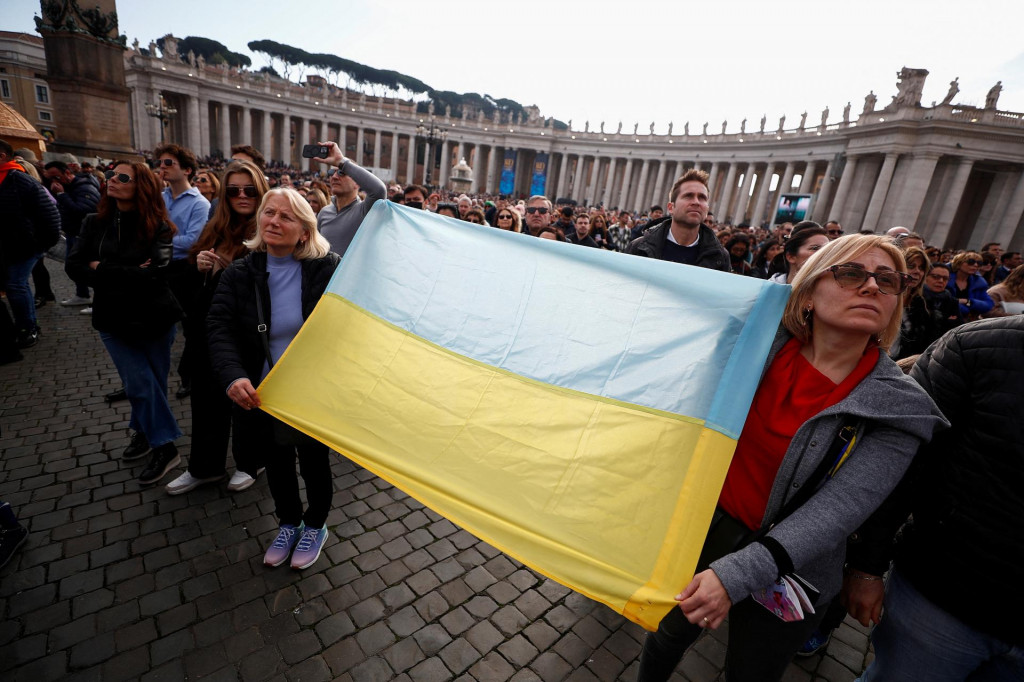 Ľudia držiaci ukrajinskú vlajku. FOTO: Reuters