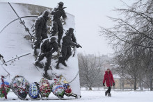 Dievča kráča okolo pamätníka pre vojakov Ruských vojenských špeciálnych síl počas sneženia v Petrohrade. FOTO: TASR/AP