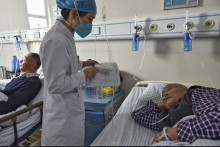 Zdravotná sestra podáva lieky starším pacientom s príznakmi ochorenia COVID-19 v nemocnici v meste Fu-jang v stredočínskej provincii An-chuej. FOTO: TASR/AP