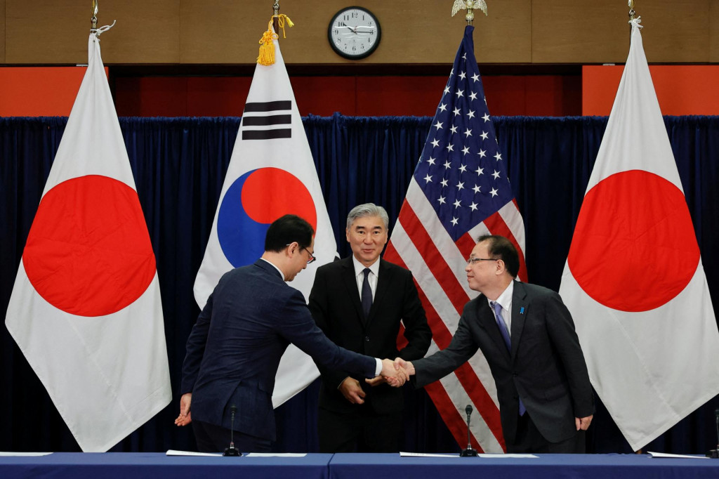 Osobitný predstaviteľ Južnej Kórey pre mierové a bezpečnostné záležitosti na Kórejskom polostrove Kim Gunn si podáva ruku s generálnym riaditeľom japonského ministerstva zahraničných vecí pre záležitosti Ázie a oceánu Funakoshi Takehirom.FOTO: Reuters