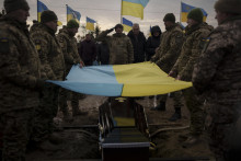Ukrajinskí vojaci držia svoju národnú zástavu nad rakvou. FOTO: TASR/AP