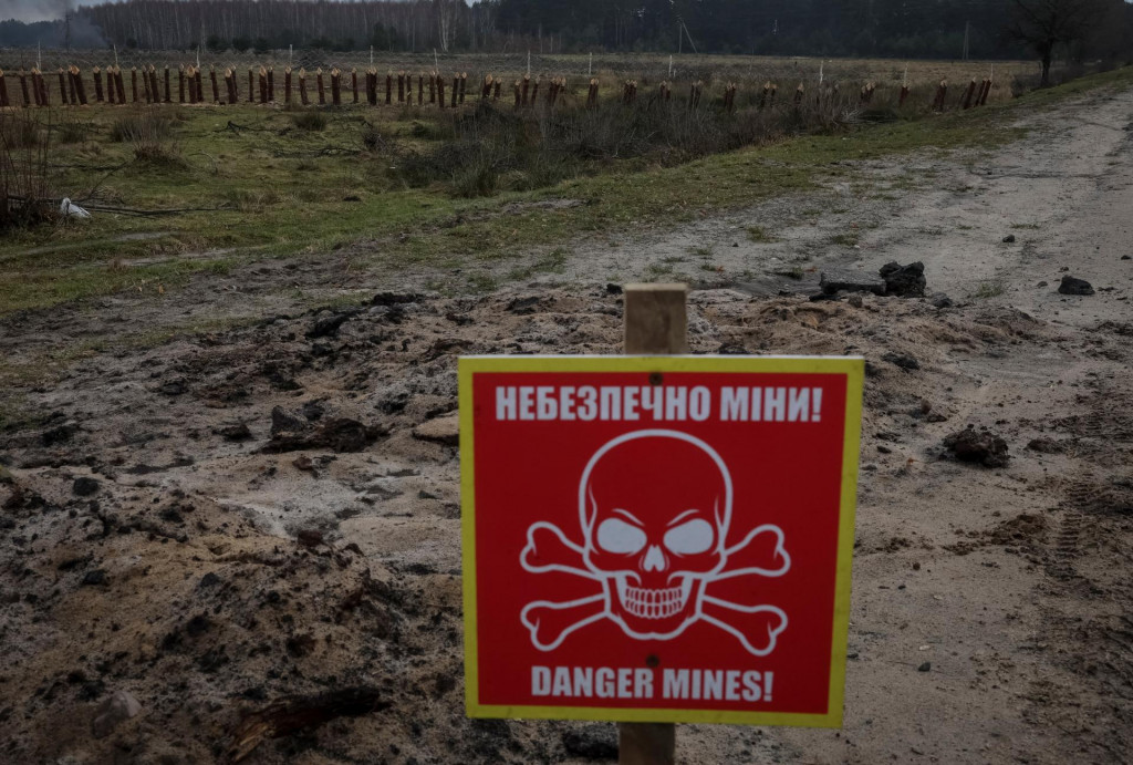 Značka mínového nebezpečenstva a protitankovej konštrukcie pri hraniciach s Bieloruskom, vo Volynskej oblasti na Ukrajine. FOTO: REUTERS