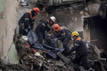 Záchranári nesú telo muža, ktorý zahynul po ruskom raketovom útoku na obytný dom v ukrajinskom meste Dnipro. FOTO: TASR/AP