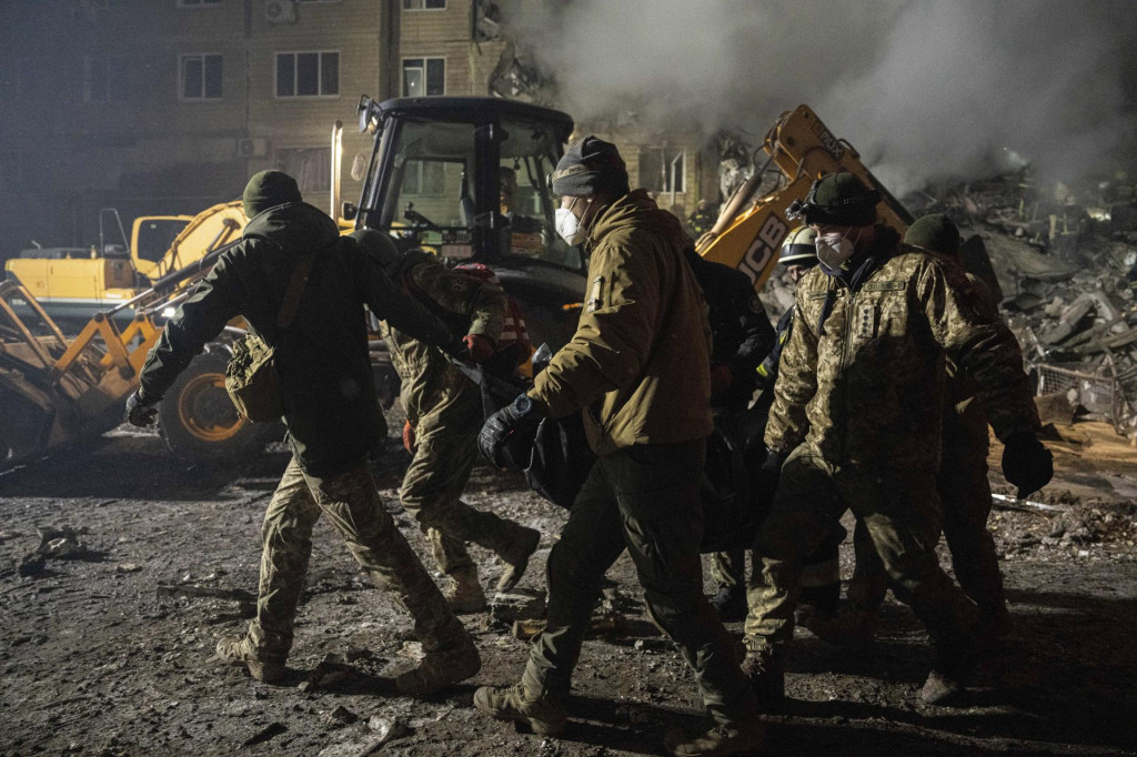 Ukrajinskí vojaci odnášajú telo muža, ktorý prišiel o život pri ruskom raketovom útoku. FOTO: TASR/AP