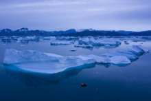 Loď pláva v noci vedľa veľkých ľadovcov pri meste Kulusuk na východe Grónska. FOTO: TASR/AP