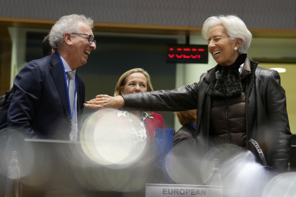 Prezidentka ECB Christine Lagardeová si podáva ruku s riaditeľom Európskeho stabilizačného mechanizmu Pierreom Gramegnom počas stretnutia ministrov financií členských krajín EÚ. FOTO: TASR/AP
