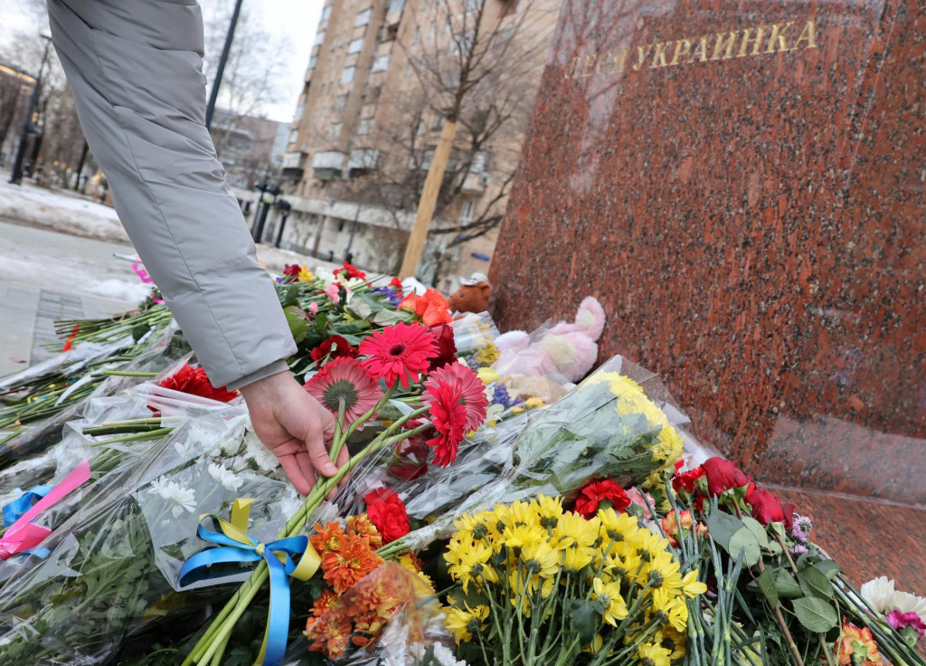 Žena kladie kvety na moskovský pomník ukrajinskej poetky a spisovateľky Kosač-Kvitkovej, známej pod pseudonymom Lesja Ukrajinka. Pamätník momentálne slúži ako symbol spolupatričnosti s obeťami tragédie v ukrajinskom meste Dnipro. FOTO: Reuters
