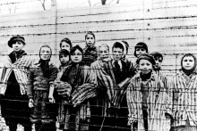 Skupina detí vrátane Marthy Weissovej stojí za ostnatým drôtom v nacistickom koncentračnom tábore v Osvienčime tesne po tom, ako tábor oslobodili sovietske jednotky. FOTO: TASR/AP