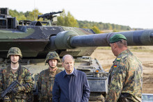 Na archívnej snímke zo 17. októbra 2022 nemecký kancelár Olaf Scholz a nemeckí vojaci stoja pri tanku Leopard 2 počas vojenského cvičenia v nemeckom Ostenholzi. FOTO: TASR/AP