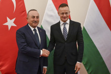 Maďarský minister zahraničných vecí Péter Szijjártó (vpravo) a turecký minister zahraničných vecí Mevlüt Čavušoglu si podávajú ruky počas stretnutia. FOTO: TASR/AP
