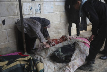 Žena identifikuje telá obetí zemetrasenia v meste Azmarin. FOTO: TASR/AP