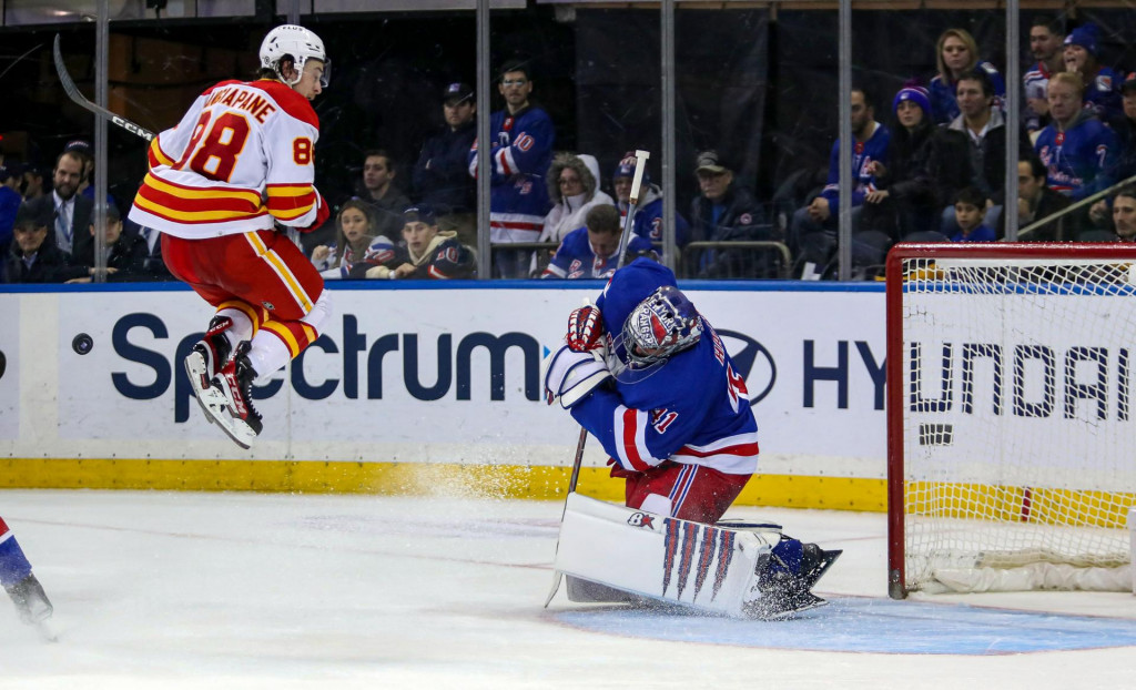 

Ľavé krídlo Calgary Flames Andrew Mangiapane naskakuje v Madison Square Garden pred brankára New York Rangers Jaroslava Haláka. FOTO: Reuters/USA TODAY Sports/Danny Wild
