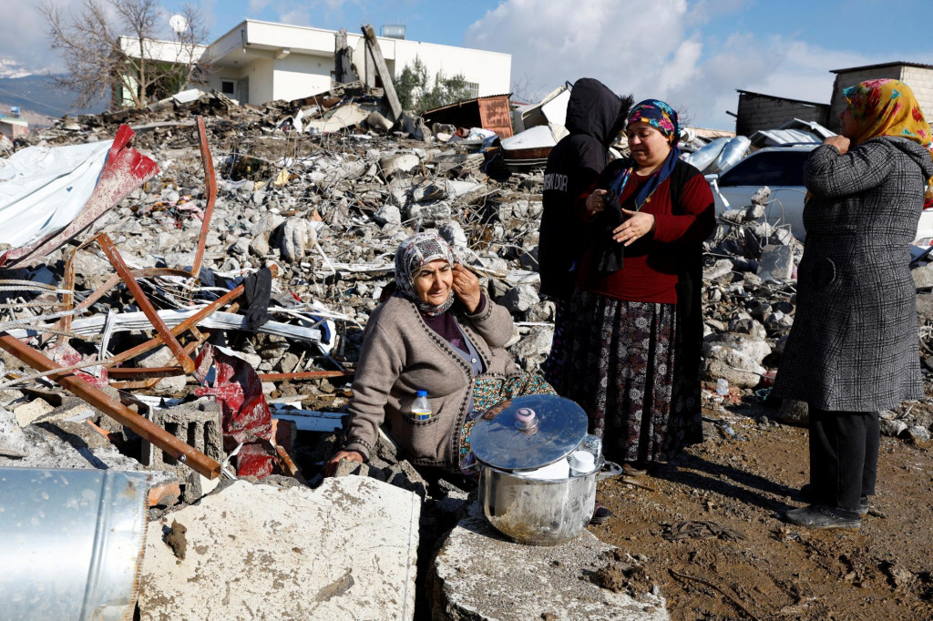 Žena sedí medzi troskami a škodami po zemetrasení v Gaziantepe v Turecku 7. februára 2023. FOTO: REUTERS