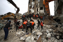 Pracovníci civilnej obrany prehľadávajú ruiny zrútených budov v sýrskom meste Hama. FOTO: TASR/AP