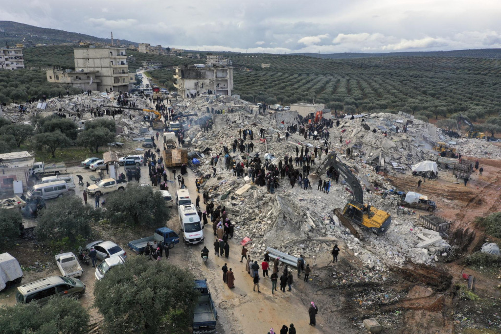 Pracovníci civilnej obrany a obyvatelia prehľadávajú ruiny zrútených budov v meste Harem pri tureckých hraniciach v sýrskej provincii Idlib. FOTO: TASR/AP