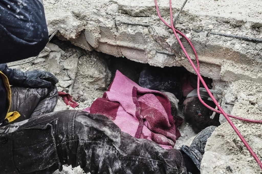 Príslušníci sýrskej civilnej obrany prehľadávajú trosky budovy, ktorá sa zrútila v sýrskom meste Afrín. FOTO: TASR/AP