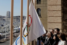 Starosta Marseille Benoit Payan (vľavo) vztyčuje olympijskú vlajku so šéfom olympijského výboru Olympijských hier 2024 v Paríži Tonym Estanguetom (uprostred vpravo). FOTO: TASR/AP