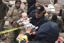 Zachránené dieťa zo zničenej budovy v tureckom meste Malatya. FOTO: TASR/AP