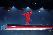 Rihanna vystupuje na pohyblivom pódiu zavesenom vysoko nad ihriskom a postupne klesajúcom k hracej ploche štadióna. FOTO: Reuters