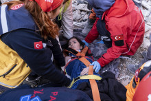 Záchranári a zdravotníci vyťahujú ženu z trosiek zrútenej budovy v meste Antakya na juhovýchode Turecka. FOTO: TASR/AP