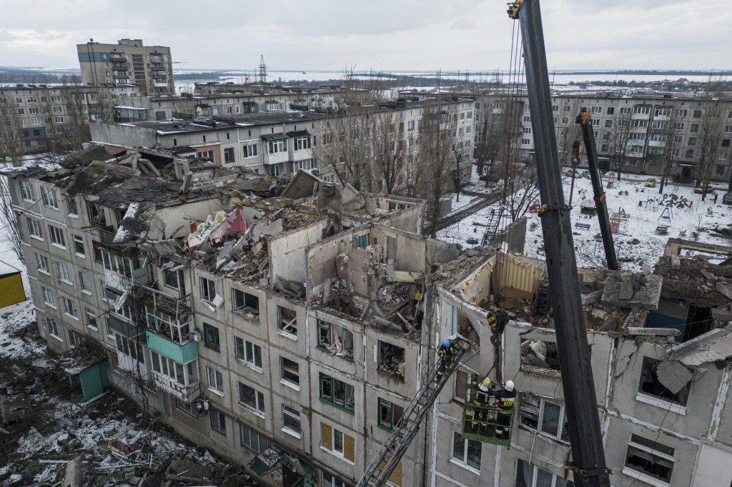 Hasiči odstraňujú trosky z obytnej budovy, ktorú zničila ruská raketa. FOTO: TASR/AP