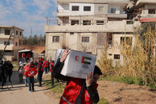 Sýrsky spolupracovník Červeného arabského polmesiaca nesie škatuľu s humanitárnou pomocou. FOTO: Reuters